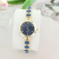 Nahaufnahme der Luxus Damen Quarzuhr mit blauem Zifferblatt und diamantbesetztem Armband. - Goldblau
