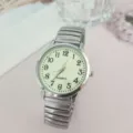 Close-up van de kwartsuurwerk wijzerplaat met grote cijfers en elastische metalen band. - Herenstijl / Zilver Groen (Mannen)