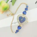 Nahaufnahme der herzformigen blauen Zifferblatt Strass Damen Quarzuhr mit goldener Kette. - Gold Blau