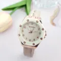 Primo piano dettagliato di un elegante orologio da donna al quarzo oro rosa con lunetta bianca. - Beige