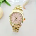 Close-up view of gold quartz watch detail featuring pink dial and rhinestone markers. - Women / Gold Pink