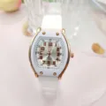 Detailansicht der weißen Quarzarmbanduhr mit tonnenförmigem goldenen Zifferblatt und Zeigern. - Weißes Silikonarmband Uhr