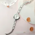 Detailaufnahme Damen Quarz Armbanduhr mit Strass Steinen, glänzendes edles Schmuck Armband Design. - Silber