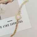 Detailaufnahme einer luxuriösen goldenen Quarzuhr mit Zifferblatt und funkelnden Strasssteinen. - Goldgehäuse Rosa