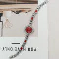Nahaufnahme einer eleganten Damenuhr mit rotem Zifferblatt und funkelndem Armband. - Silbergehäuse Rotes Zifferblatt