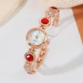 Elegante roségoldene Damenuhr Quarz mit roten Steinen und klarem Kunststoffständer. - Roségold Rot