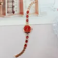 Detailansicht der goldenen Damen Quarz-Armbanduhr mit roten Edelstein-Dekor und feinem Armband. - Roségold Rot Zifferblatt