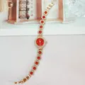 Detailaufnahme der goldenen Damen Quarzurhr mit roten runden Steinen und funkelnden Kristallen. - Roségold Rot