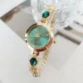 Close-up detail of women quartz watch featuring green dial, crystal stones, and gold strap. - Green