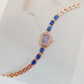 Primo piano dettaglio di elegante orologio donna al quarzo, lunetta strass con cristalli blu. - Oro Rosa Blu