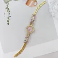 Elegante goldene Damen Quarzuhr mit rosafarbenem Zifferblatt und lila Kristallblumen. - Gold Violett