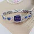 Damen Quarzuhr mit quadratischem Zifferblatt, funkelnden Strasssteinen und blauem Armband. - Silber & Blau
