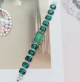 Gedetailleerd overzicht van dames groen kwartshorloge met edelstenen armband en wijzerplaat. - Zilver Groen