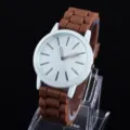 Schlichte Quarzuhr mit weißem Zifferblatt, weißem Gehäuse und braunem Silikonarmband im Alltag. - Braun