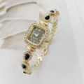 Nahaufnahme einer goldenen quadratischen Strass-Quarzuhr mit schwarzen Tropfenarmband. - Schwarz