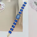 Exquisite crystal quartz watch with blue rectangular dial and sparkly gem bracelet fashion accessory. - Gold Blue