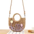 Handmade woven straw crossbody bag with floral decor and purple letter design for daily use. - Camel + Purple Letters