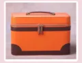 Elegante cosmetische koffer van oranje leer met bruine accenten voor stijlvolle reizen. - Oranje