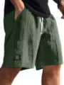Close-up detail of mens dark green knitted jacquard casual shorts with white drawstring. - Green