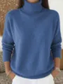 Close-up detail of the cozy blue turtleneck knit sweater, showing soft texture and fine stitching. - Blue