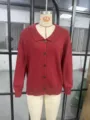 Detaillierte Nahaufnahme einer roten Damen Strickjacke mit klassischem Reverskragen und Knöpfen. - Rot