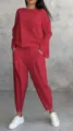 Detail view of stylish red long sleeve sweatshirt and harem pants set worn by model. - Red