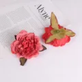 Nahaufnahme Detailaufnahme roter künstlicher Rosenköpfe mit Blütenblatt- und Kelchblatttexturen. - Rot