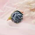 Nahaufnahme einer blauen künstlichen Blumenkopf auf rosafarbenem Netzstoff mit Pampasgras. - Stil 1