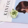 Close-up detail view of a green artificial rose flower head, ideal for photography props. - Style 11