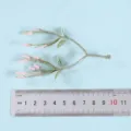 Close-up detail of artificial plant branch with pink buds and green leaves, ideal decor. - Style 8