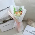 Vista detallada de un ramo de flores de jabón de rosas artificiales con papel delicado y cinta elegante. - Rosa