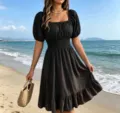 Detailed view of a stylish black square neck midi dress with puff sleeves and beach setting. - S / Black