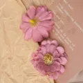 Close-up detail of pink artificial daisy flower heads, fabric material, for DIY crafts decor. - Violet