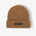 Detail view of brown knitted winter beanie hat with black patch, warm and stylish. - One Size / Khaki