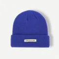 Classic royal blue knit beanie winter warm hat with stylish front beige cloth tag detail. - One Size / Blue