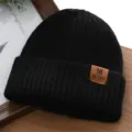 Schwarze Strickmütze Detail, warme Wintermütze mit braunem Leder-Label Akzent. - Einheitsgröße / Schwarz