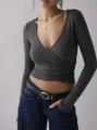 Λεπτομερής εικόνα του σκούρου γκρι crop top με μακριά μανίκια και V λαιμόκοψη, στενή γραμμή. - Γκρι