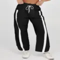 Details van zwarte wijde joggingbroek met contrasterende witte strepen en trekkoord. - S / Zwart