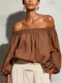 Primo piano dettagliato della elegante blusa marrone con spalle scoperte e maniche. - Marrone