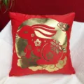 Detailed close-up shot of the red plush throw pillow featuring festive gold rabbit and cloud decor. - 45x45cm / Pattern C
