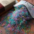 Colorful disposable hair rubber bands detail shot, showing elastic hair ties pouring out. - 1000 Pieces/Pack / Spring Colors