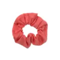 Detail shot of a soft coral pink fabric scrunchie, showing fine texture and elasticity. - Coral Pink