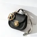 Mini borsa a sella nera in pelle portachiavi con dettagli dorati e foulard stampato chic. - Nero