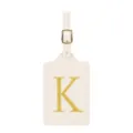 Détail d'étiquette de bagage en cuir beige avec monogramme brodé doré et boucle. - Lettre K / Blanc Cassé