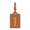 Gros plan sur l'étiquette de bagage en cuir PU marron avec boucle dorée et lettre jaune. - Lettre I