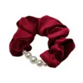 Close-up detail of a red velvet hair scrunchie featuring elegant white pearl decorations. - Red