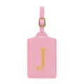Dettaglio etichetta bagaglio in ecopelle rosa con lettera J ricamata oro e fibbia. - Rosa J
