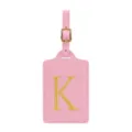 Primo piano dettagliato dell'etichetta bagaglio in pelle PU rosa con lettera K ricamata d'oro. - Rosa K