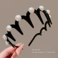 Pearl detail close-up of the black wave hair hoop, showcasing teeth and elegant pearl decor. - White