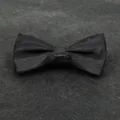 Primo piano del dettaglio del papillon nero in jacquard, elegante trama per abito da uomo - 001